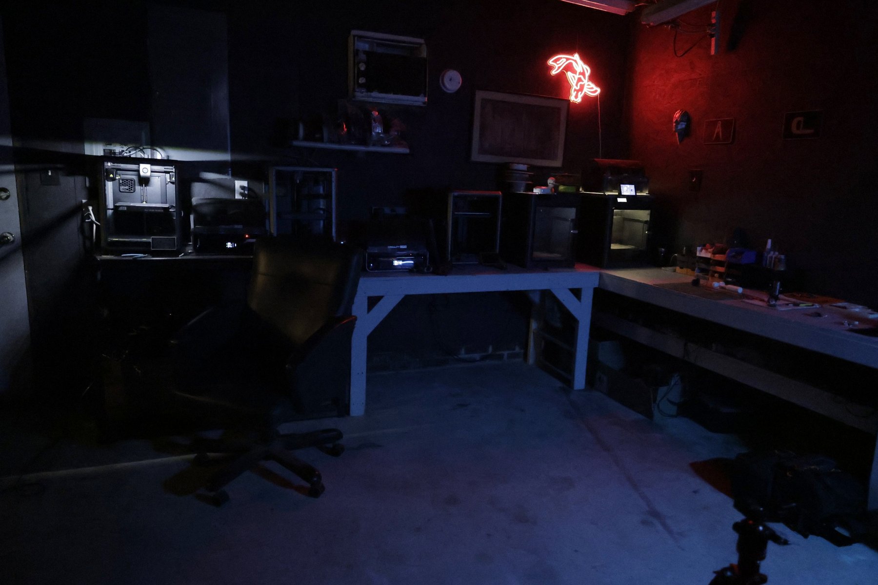 The full TacticalTech3D print room: the printer bench, the workbench, and the red neon sign on the wall.